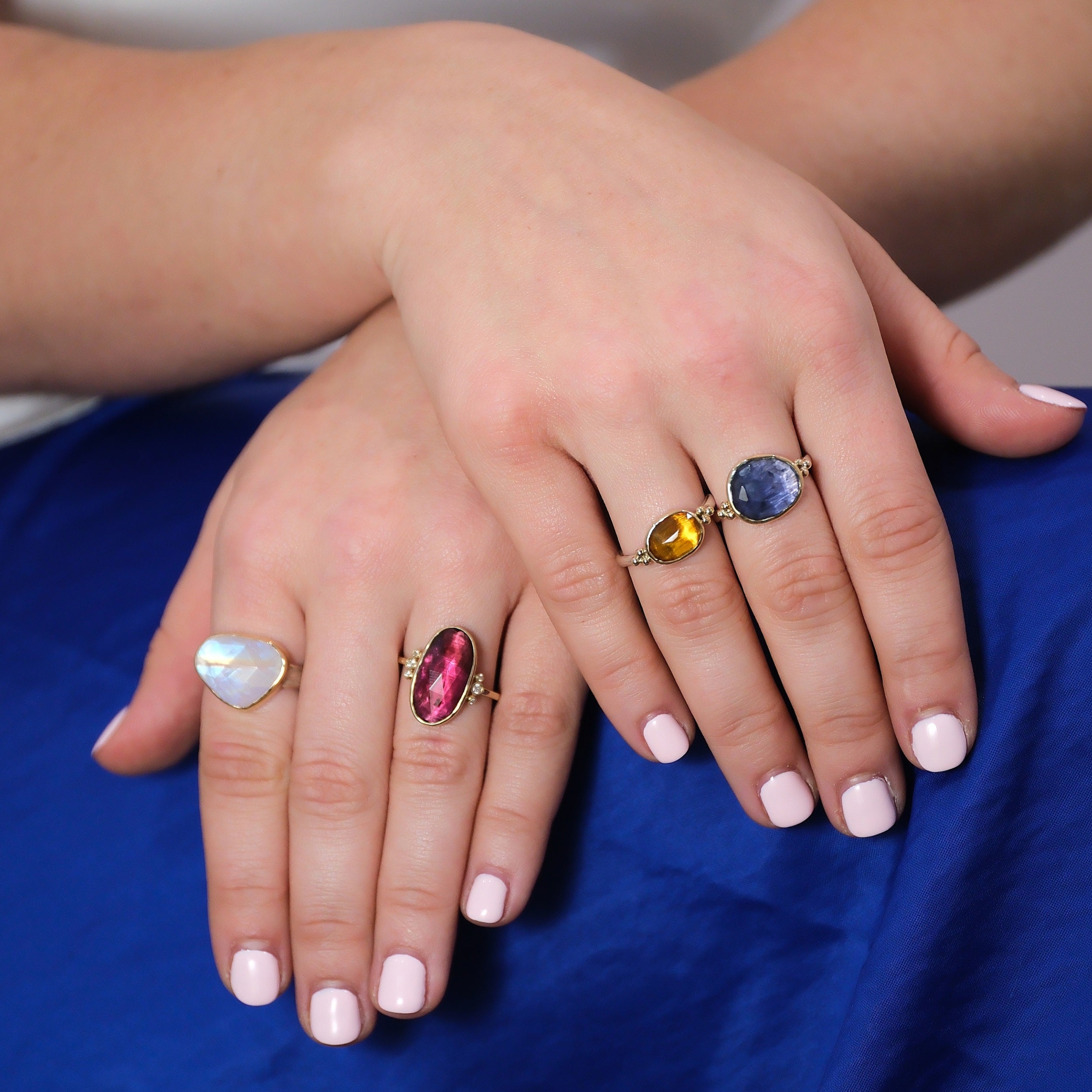 A variety of Emily Amey gemstone rings including moonstone and tourmaline