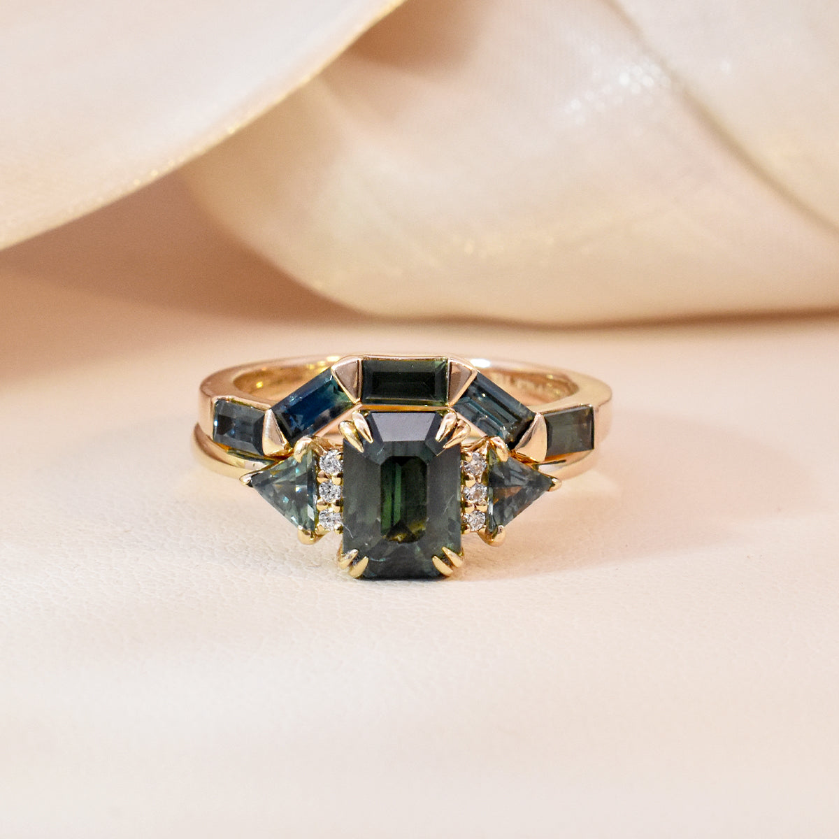1.76ct Emerald-Cut Teal Sapphire & Triangle Side Stones paired with a Teal Sapphire Baguette Contour Band
